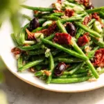 A colorful Mediterranean green bean salad featuring fresh veggies and herbs.