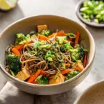 Soba noodle stir fry with tofu and colorful vegetables in a bowl