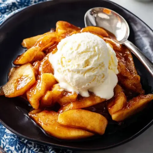 Crispy and caramelized air fryer apples served in a bowl, showcasing a delicious dessert.