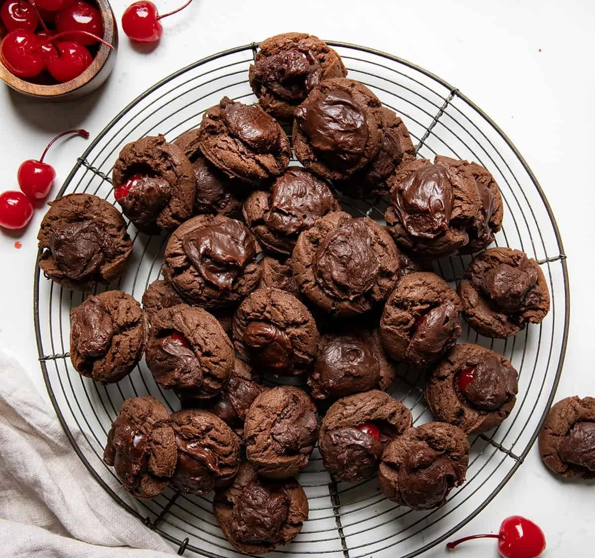 Plate of homemade Chocolate Covered Cherry Cookies with cherries and chocolate glaze.
