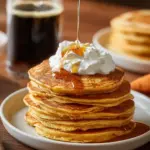 Delicious and fluffy sweet potato pancakes topped with syrup and berries.