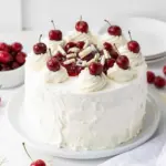 Slice of White Forest Cake with cream and cherries on top