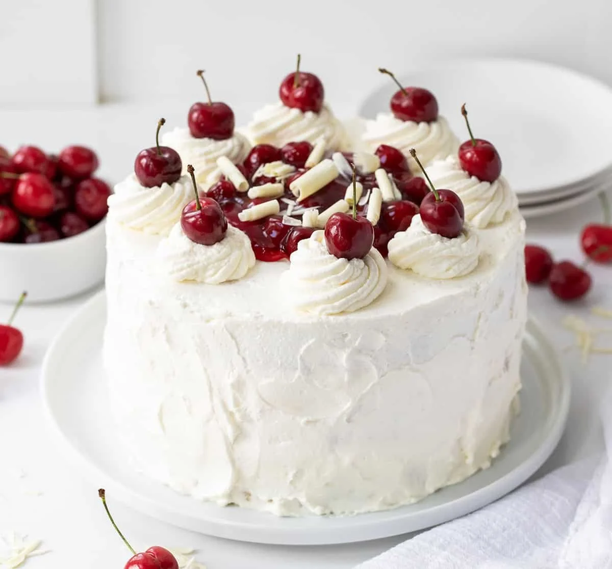 Slice of White Forest Cake with cream and cherries on top